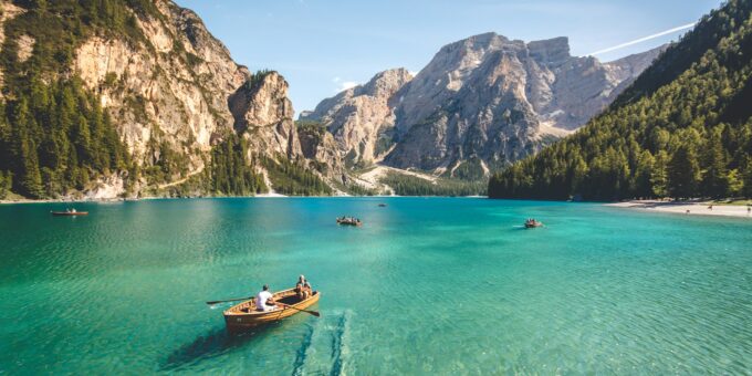 three brown wooden boat on blue lake water taken at daytime